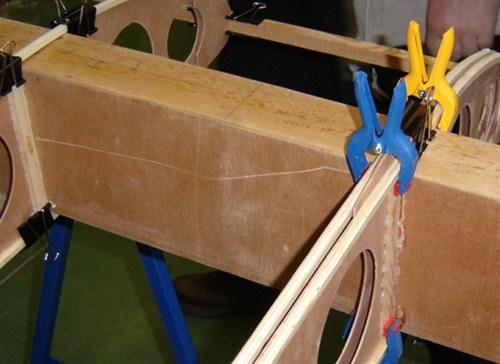 OK, the hingeline-ribs are different. They are two ribs at the same place. Place about 3 mm between them. Just enough to let a saw pass. You cannot glue the ribs fromt he inside here. You need to do it after you cut the wing in three parts at the hinge-line. Our clamp was too small to cover this distance. Luckily I had already these larger plastic clamps.